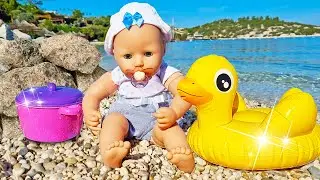 Çocuklar için su oyunları. Baby Born oyuncak bebek plajda oynuyor. Bebek bakma oyunu.